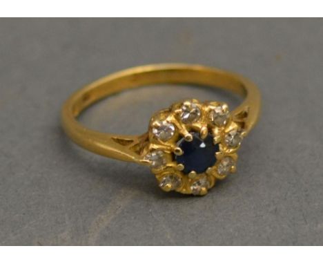 An 18ct. Yellow Gold Diamond and Sapphire Set Cluster Ring with a central Sapphire surrounded by Diamonds 