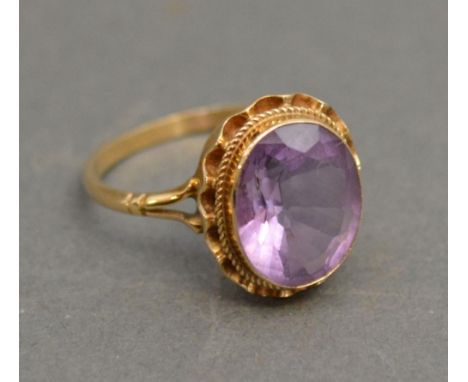 A 9ct. Gold Amethyst Dress Ring with a large oval amethyst within a pierced setting 