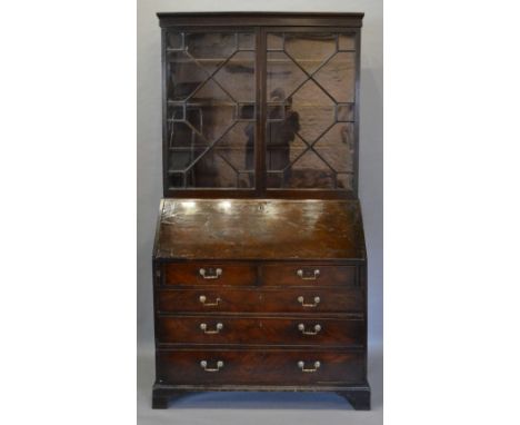 A George III Mahogany Bureau Bookcase, the moulded cornice above two astragal glazed doors enclosing shelves, the lower secti