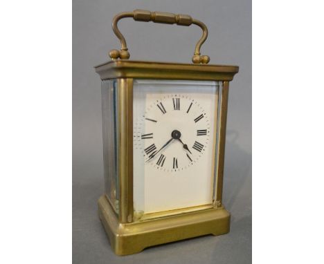 A French Brass Cased Carriage Clock, the enamel dial with Roman numerals and with lever escapement and carrying handle, 11 cm