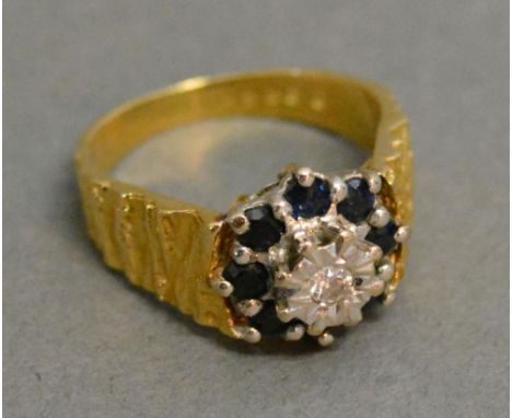 An 18ct. Yellow Gold Diamond and Sapphire Cluster Ring with a central diamond surrounded by sapphires 