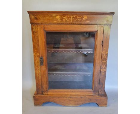 A Victorian Walnut Marquetry Inlaid Pier Cabinet with a glazed door enclosing shelves raised upon bracket feet, 76cms wide, 3