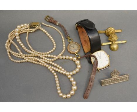 A 9ct. Gold Cased Ladies Wrist Watch together with an Eterna gentleman's wrist watch, three cap badges and simulated pearl ne