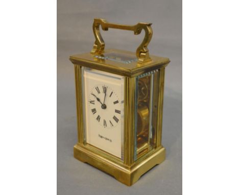 A Brass Cased Carriage Clock retailed by Mappin & Webb, the enamel dial with Roman numerals and with visible escapement and c