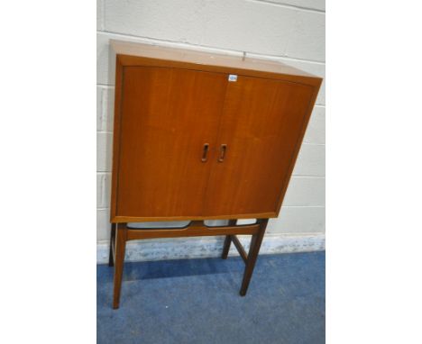 POSSIBLY TORBJORN AFDAL, A MID CENTURY TEAK COCKTAIL CABINET, the double cupboard doors enclosing a mirrored and fitted inter