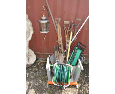 A COLLECTION OF GARDEN TOOLS AND A MODERN WROUGHT IRON LANTERN including a galvanised tin bath, forks, spades, kneelers, a ho