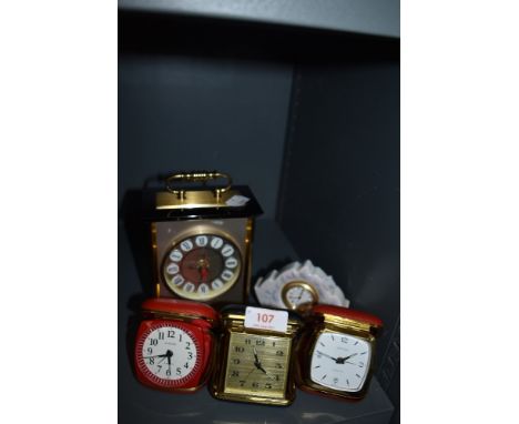 Three vintage travel clocks and a carriage/mantel clock also included is a Lladro ceramic clock.