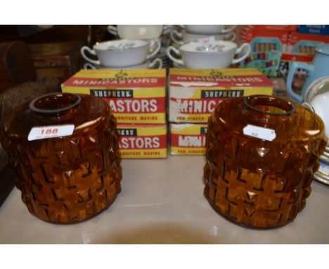 Two mid century amber coloured glass lamp shades and four boxes of Shepherd Minicastors.