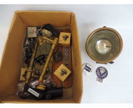 A box of assorted parts to include new old stock parking lamps, plus two ex-WD brass air pumps, a Lucidus lamp etc. 