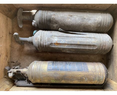 Three vintage fire extinguishers, one on original bracket. 