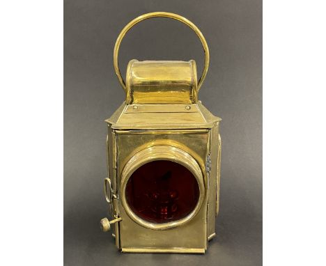 A Howes &amp; Burley Ltd. polished brass rear lamp with red glass lens. 