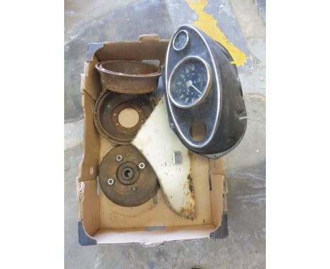 A box of mostly Mini spares including an oval dashboard console with speedometer fitted and brake drums. 