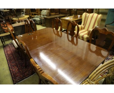 A reproduction mahogany twin pillar extending dining table and eight George I style chairs, 300cm extended (two spare leaves)