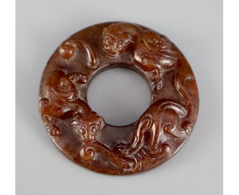 A Chinese brown jade bi disc, carved in relief with chilong, 5cm diameter