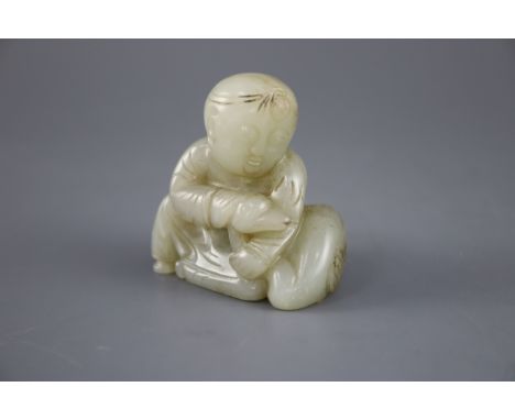 A Chinese pale celadon jade group of a seated boy and a duck, the stone with some occasional russet veining, Collection label