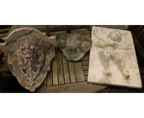 A plaster cherub plaque, a reconstituted stone bracket and a ram's head wall mask, largest 56 x 36cm