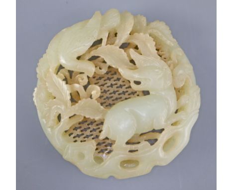 A Chinese pale celadon jade circular plaque, carved in relief and openwork with a qilin and a bird amid foliage, 6.2cm diamet