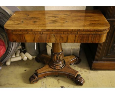 An early Victorian rosewood card table, having D-shaped folding top lined with foliate-decorated baize