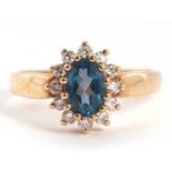 A 9ct topaz and diamond cluster ring, the oval topaz surrounded by small round brilliant cut
