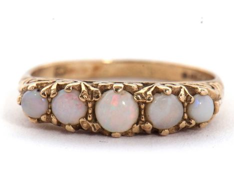 A 9ct opal ring, set with five graduated round opal cabochons, claw mounted with scrolled gallery and plain band hallmarked L