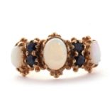 An opal and sapphire ring, the three slightly graudated oval opals, interspaced with two round
