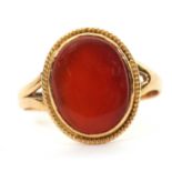 An unmarked agate ring, the oval agate cabochon, with closed back, split shoulders and plain band of