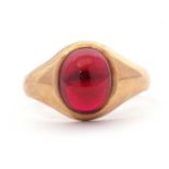 A 9ct garnet ring, the oval garnet cabochon in collet mount with tapered shoulders and plain band