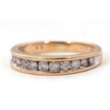 A 9ct diamond ring, the upper half with graudated channel set round brilliant cut diamonds, total