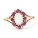 A 9ct opal, ruby and diamond ring, the oval opal cabochon surrounded by small round rubies and