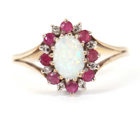 A 9ct opal, ruby and diamond ring, the oval opal cabochon surrounded by small round rubies and diamonds, with split shoulders