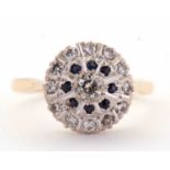 A sapphire and diamond cluster ring, the central round brilliant cut diamond surrounded by a ring of