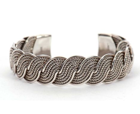 A Celtic style torque bangle, with twisted effect allover, opened with flattened ends with engraved decoration, stamped 925 t