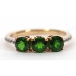 A 9ct diopside and white stone ring, the three round diopside with quarter set white stone