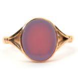 An 15ct agate signet ring, the oval unmarked agate disc, in collet mount with split shoulders and