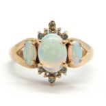 A 9ct opal and pale green hardstone ring, the cental oval opal cabochon with small round pale