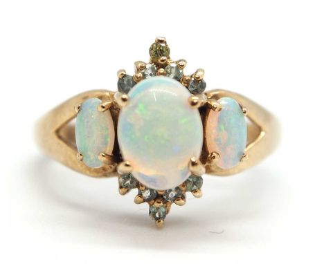 A 9ct opal and pale green hardstone ring, the cental oval opal cabochon with small round pale green hardstones above and belo