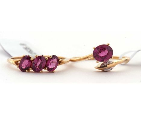 Two 9ct garnet rings: one set with three oval garnets, claw mounted to a plain band stamped 10K and 375 and hallmarked Birmin
