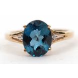 A 9ct 'London Blue' topaz and white stone ring, the oval mixed cut topaz, approx. 9.8mm long, in a