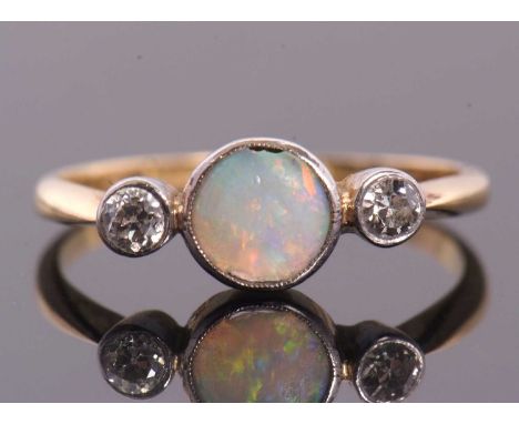 An opal and diamond ring, the round opal cabochon with a round diamond to either side, all collet mounted to a plain band ind