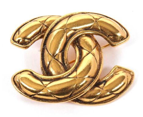 A Chanel brooch, the quilted CC logo in gilt metal and stamped 'Chanel' to reverse, 46mm wide, 21glight wear throughout and w