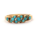 An unmarked turquoise ring, set with small round turquoise cabochons, with tapered shoulders and