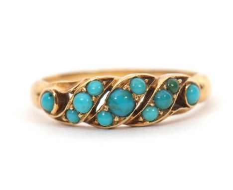 An unmarked turquoise ring, set with small round turquoise cabochons, with tapered shoulders and plain unmarked band, (tests 