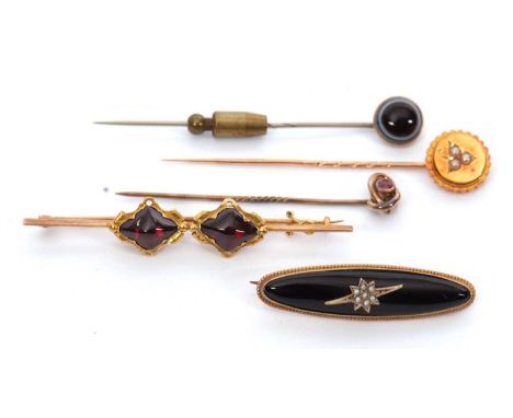 A quantity of stick pins and brooches: to include a ruby set knot stick pin stamped 9ct; a seed pearl set unmarked yellow met