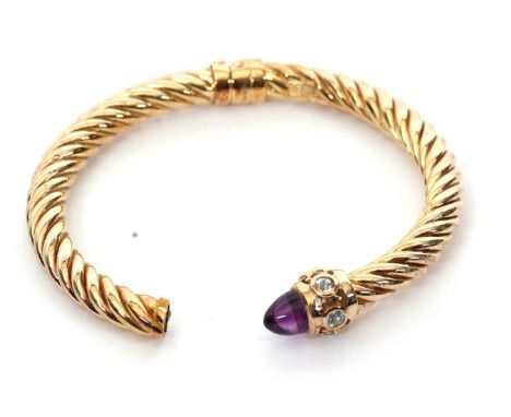 A 9ct hinged bangle, the twisted torque style bangle with tapered sugar loaf style amethyst cabocon and pale blue hardstones 