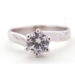 A 9ct white gold CZ ring, the round CZ, in twisted claw mount with crossover style band stamped