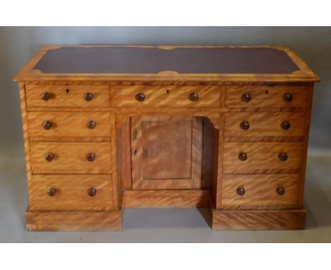 A 19th Century Satinwood Kneehole Desk, the leather inset moulded top above nine drawers with knob handles and with central k