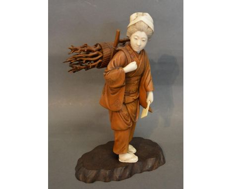 A Late 19th Early 20th Century Japanese Carved Ivory and Boxwood Figure in the form of a Girl carrying pieces of wood with ax