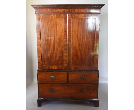 A George III Mahogany Line Inlaid Press Cupboard, the moulded cornice above two doors enclosing sliding trays, the lower sect