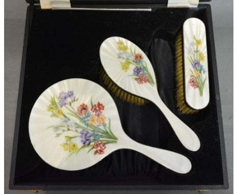 A London Silver and Enamel Decorated Dressing Table Set, comprising a hand mirror and two brushes with foliate enamel decorat