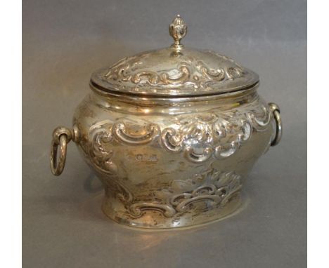 An Edwardian Silver Tea Caddy of Oval Embossed Form, with ring end handles and finial, Sheffield 1902, 10 ozs. 